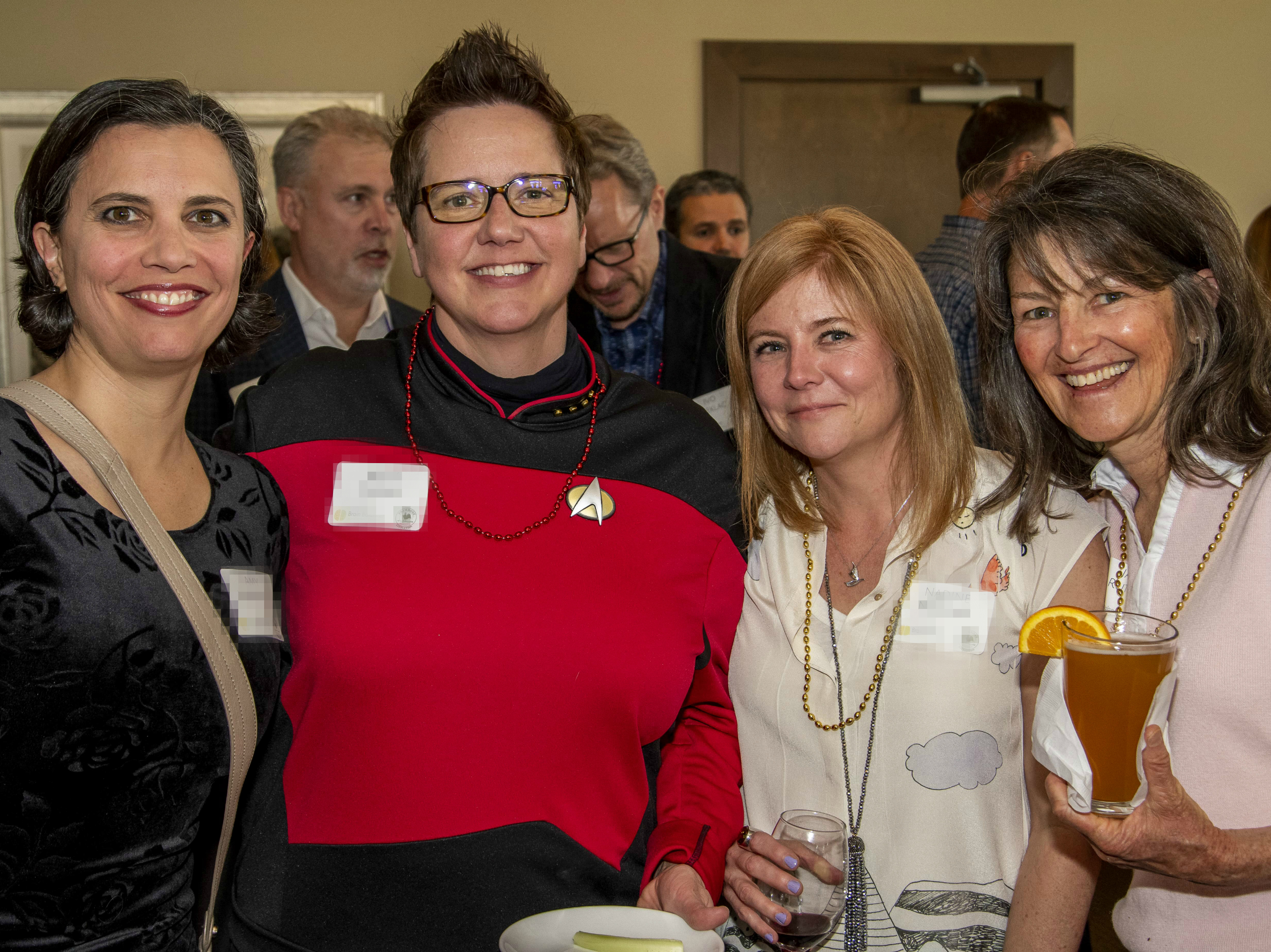 four attendees at the Mack Event smiling